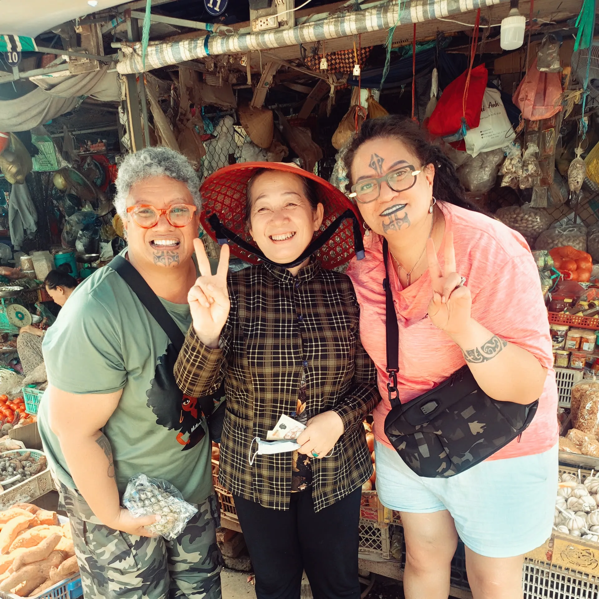 Visitors with a local vendor at a bustling market in Vinh Long
