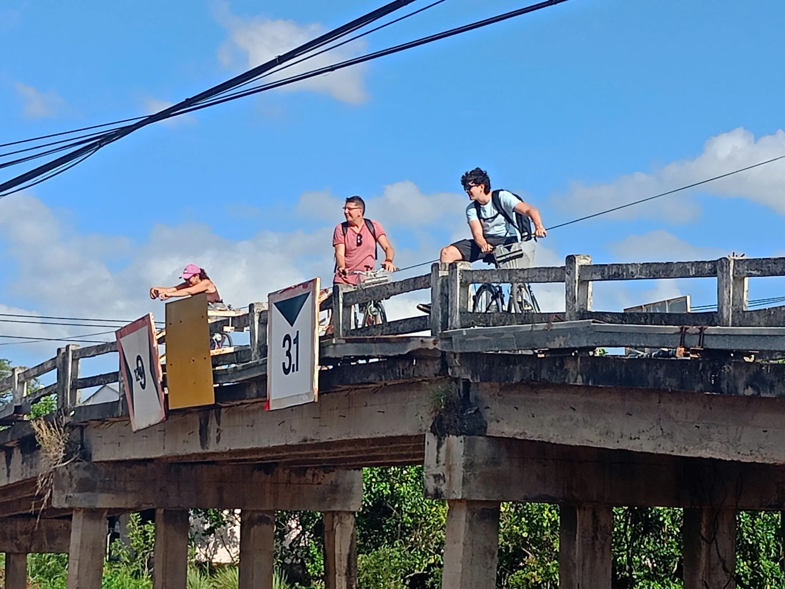 Cyclists crossing a bridge in the Mekong Delta countryside