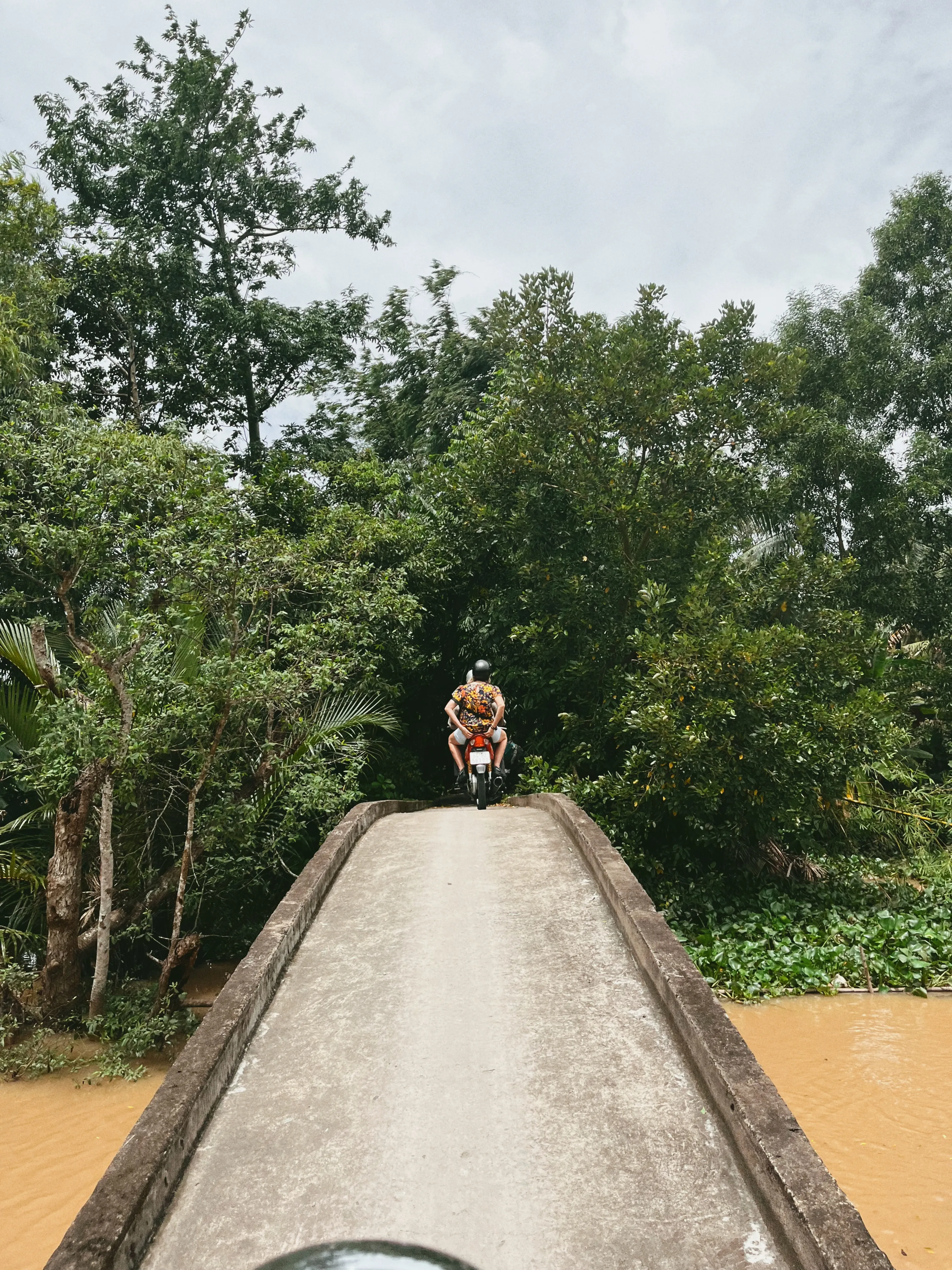 Motorbike crossing a narrow bridge over a Mekong Delta canal near Vinh Long