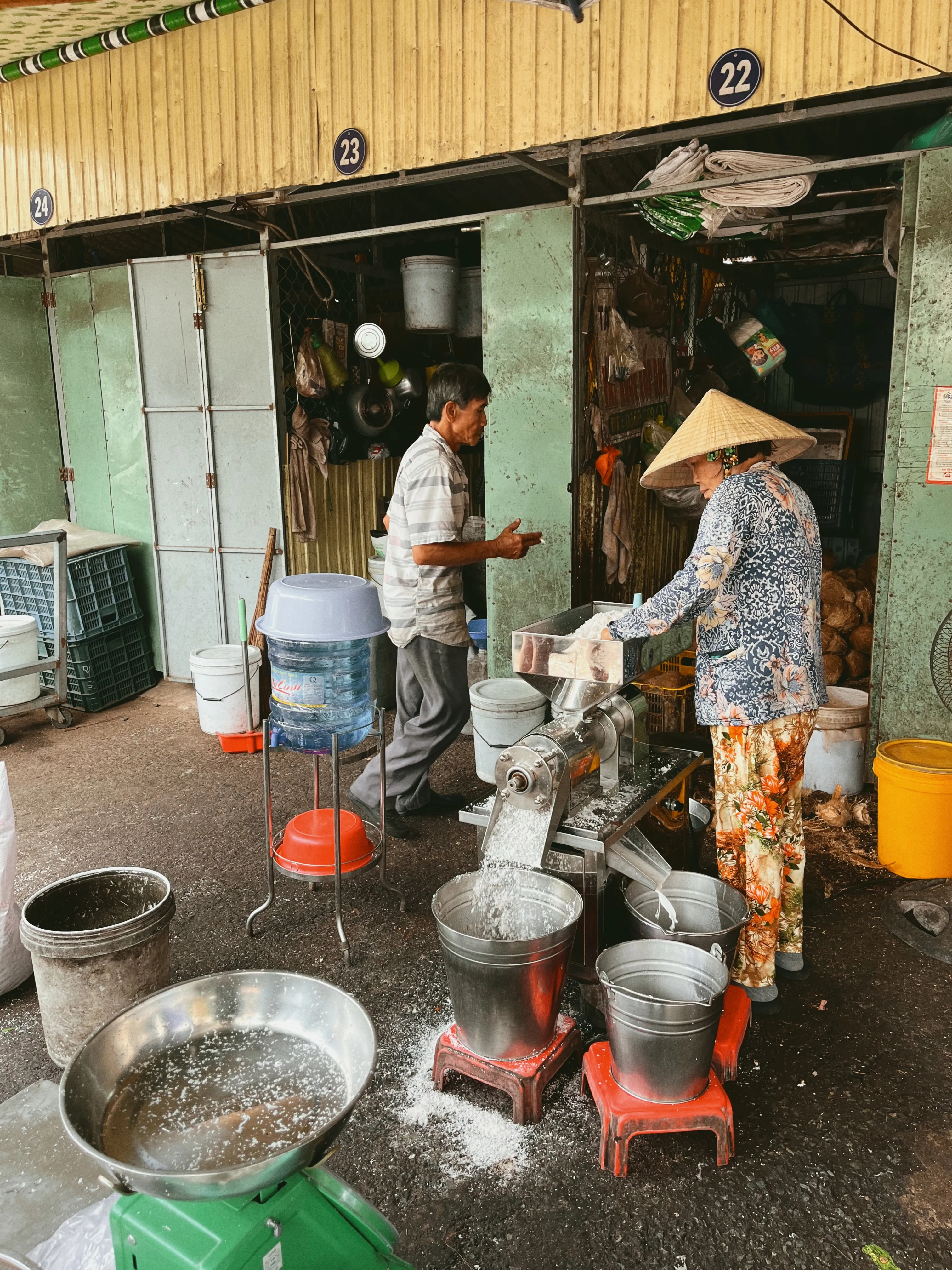 Local vendor grinding fresh coconut at a traditional market in Vinh Long