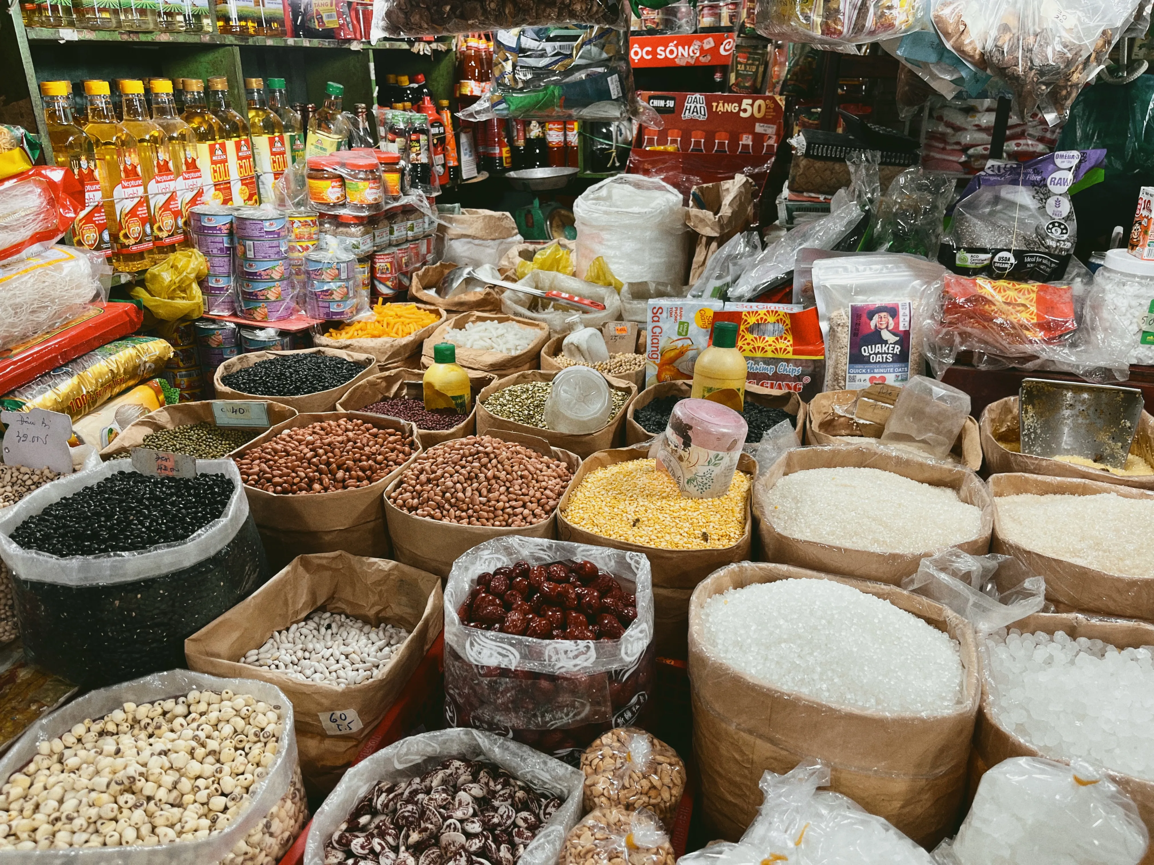Bags of rice, grains, and spices at a Vinh Long market stall