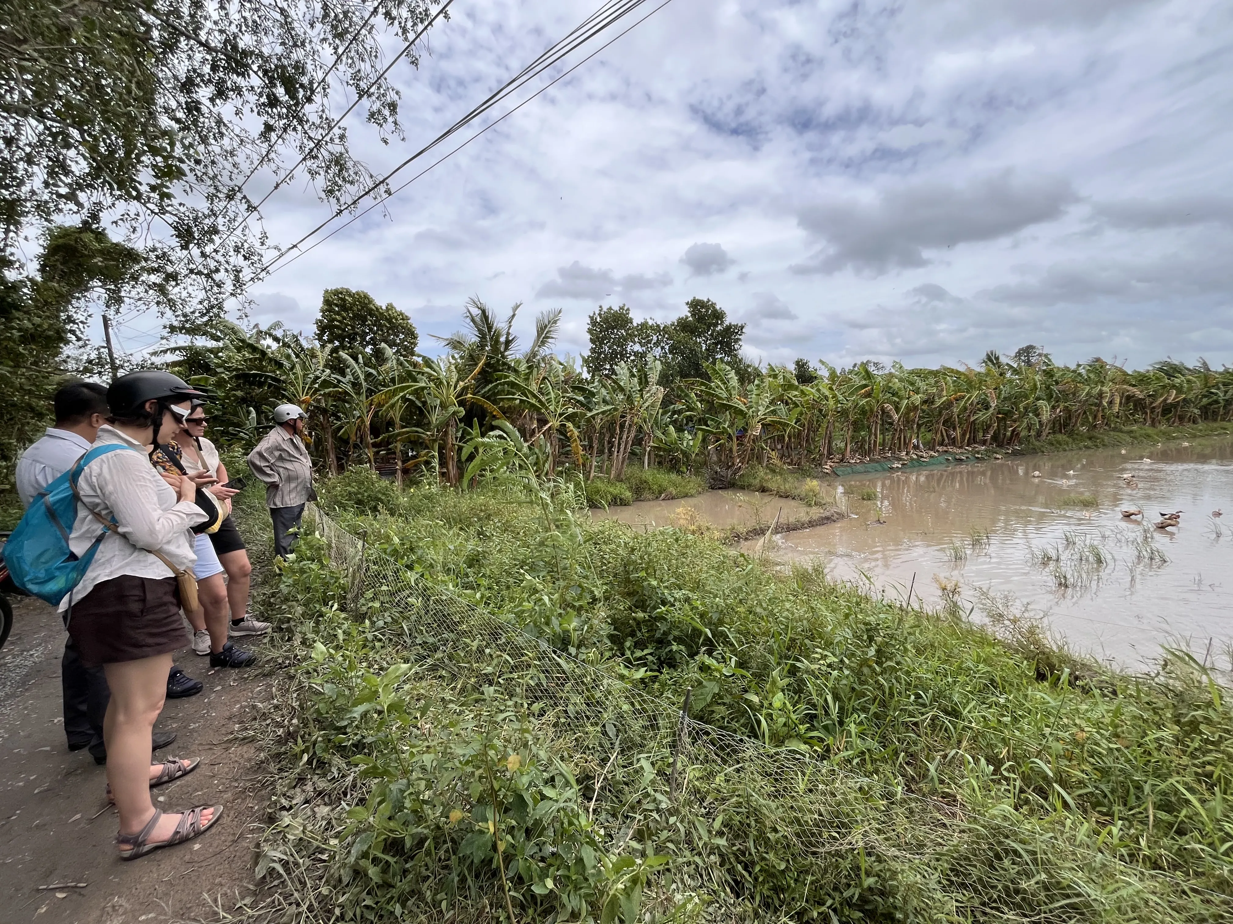 Visitors overlooking the lush riverside countryside in Vinh Long