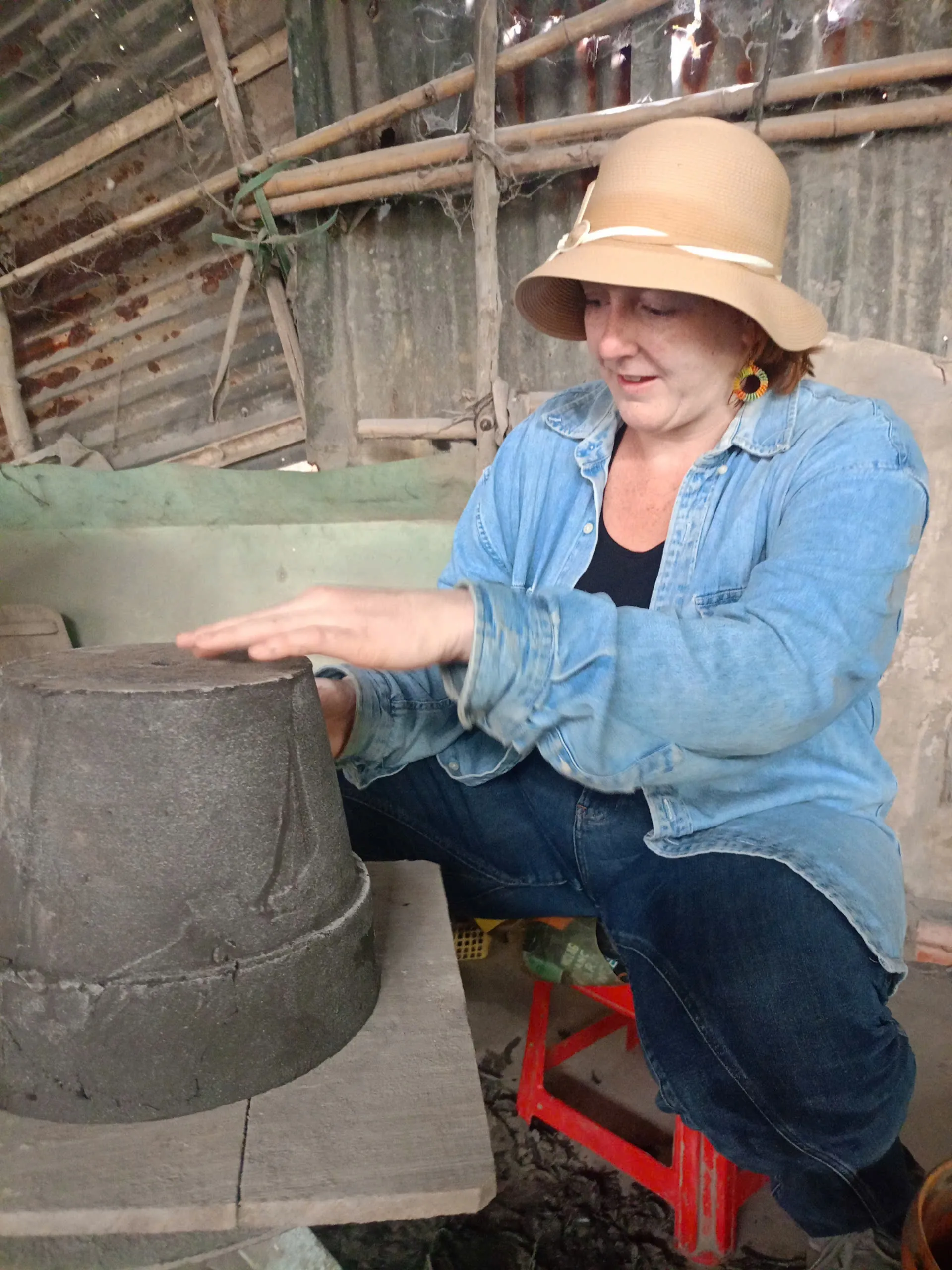 Artisan shaping a large terracotta pot by hand at a Vinh Long pottery workshop