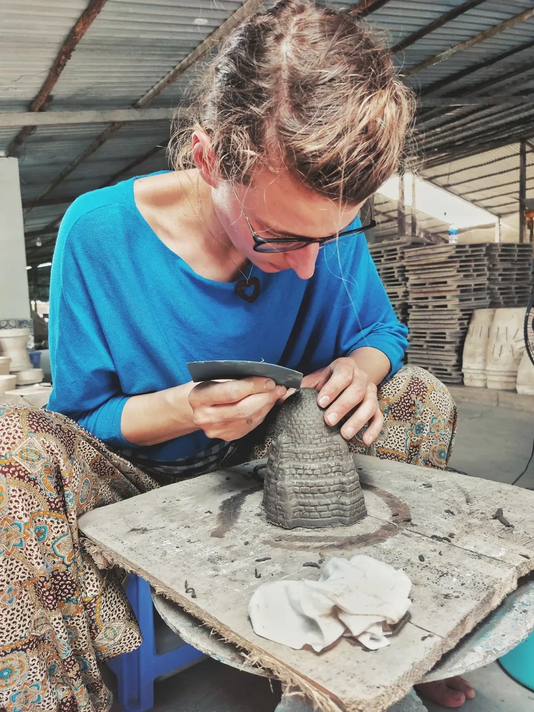 Artisan carving a clay pottery piece